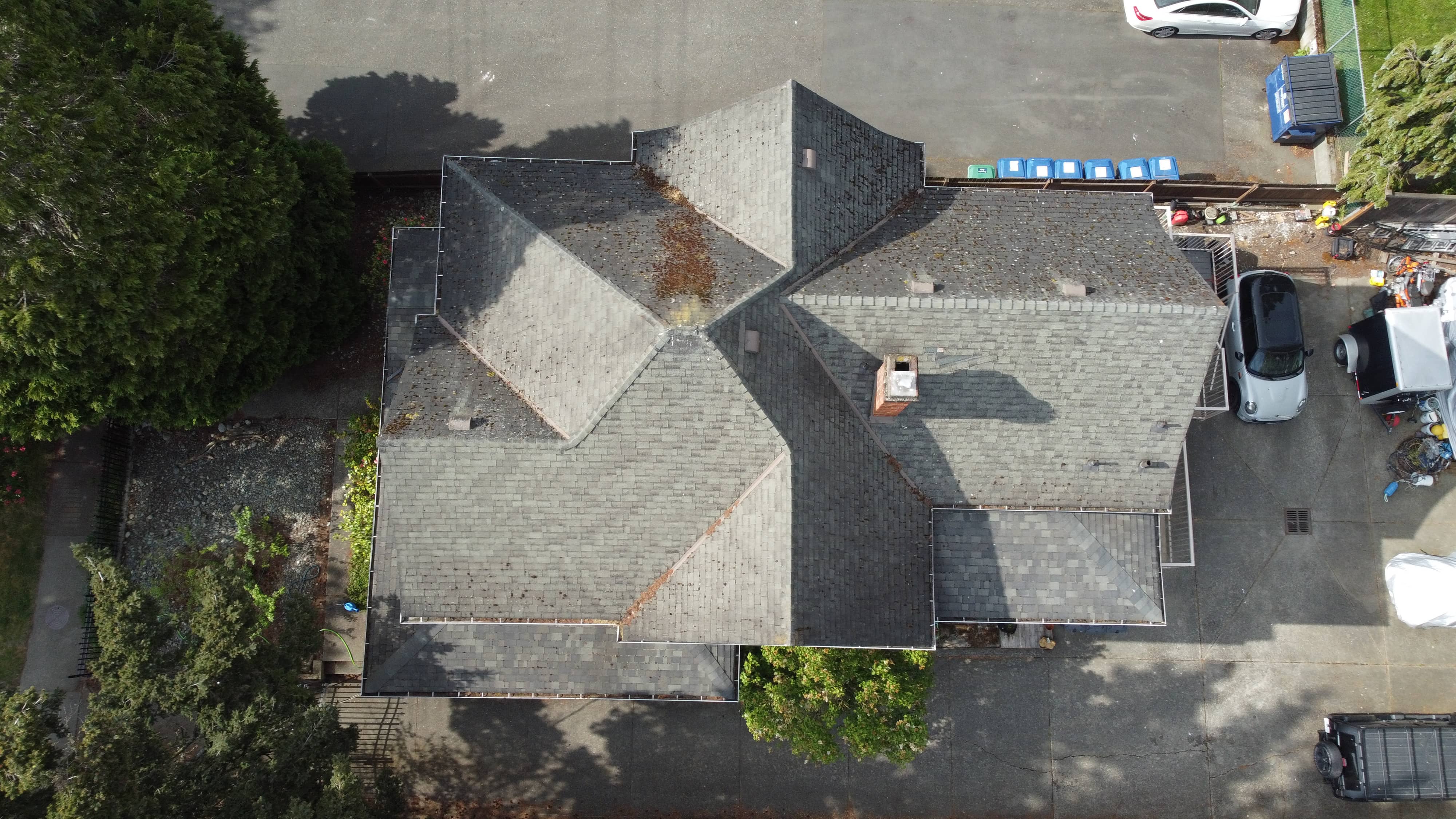 Before - aerial view of large multi-gable home with weathered moss-stained shingles in Victoria BC